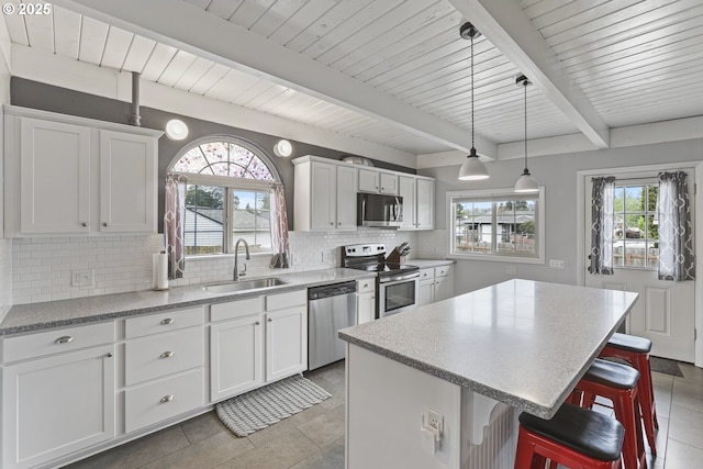 2064 Tualatin St, Saint Helens, OR 97051 - kitchen with stainless steel appliances, tasteful backsplash, a breakfast bar area, a center island, and light tile patterned floors