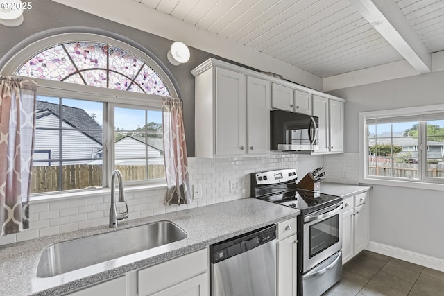 2064 Tualatin St, Saint Helens, OR 97051 - kitchen featuring appliances with stainless steel finishes, dark tile patterned floors, backsplash, a wood ceiling with exposed beams, and white cabinetry
