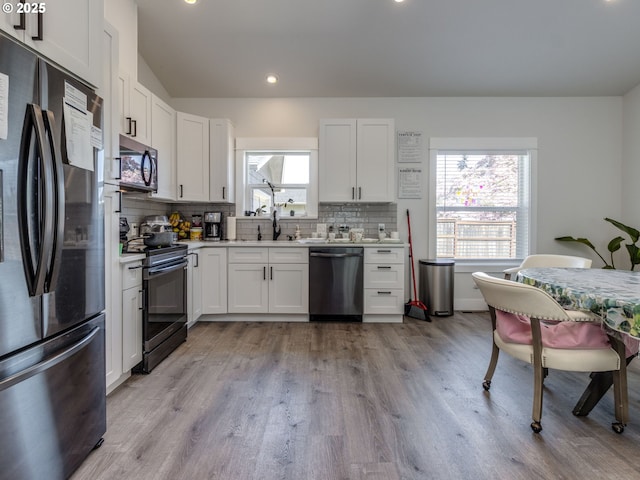 15807 SE Rainier Ave, Clackamas, OR 97015 - kitchen featuring appliances with stainless steel finishes, decorative backsplash, light wood-style flooring, and recessed lighting