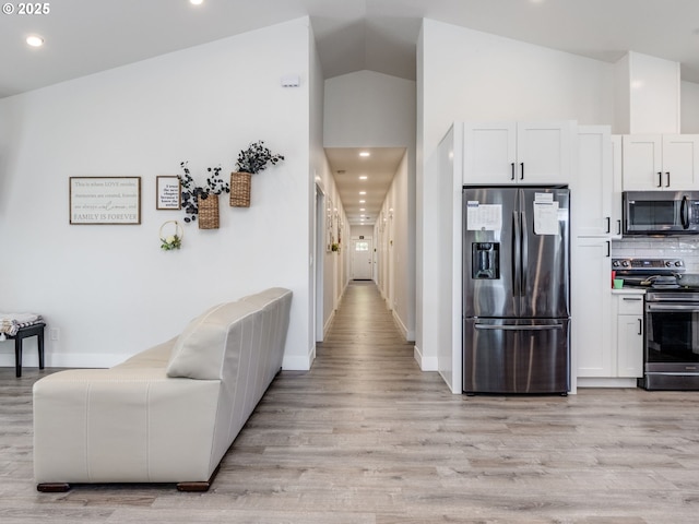 15807 SE Rainier Ave, Clackamas, OR 97015 - kitchen with appliances with stainless steel finishes, light wood finished floors, tasteful backsplash, white cabinetry, and lofted ceiling