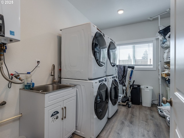 15807 SE Rainier Ave, Clackamas, OR 97015 - washroom featuring stacked washer / dryer, light wood-style floors, water heater, and cabinet space