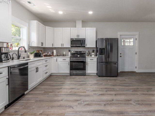 15807 SE Rainier Ave, Clackamas, OR 97015 - kitchen with stainless steel appliances, tasteful backsplash, light countertops, white cabinetry, and recessed lighting