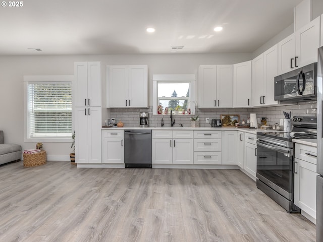 15807 SE Rainier Ave, Clackamas, OR 97015 - kitchen with stainless steel appliances, a sink, decorative backsplash, healthy amount of natural light, and recessed lighting