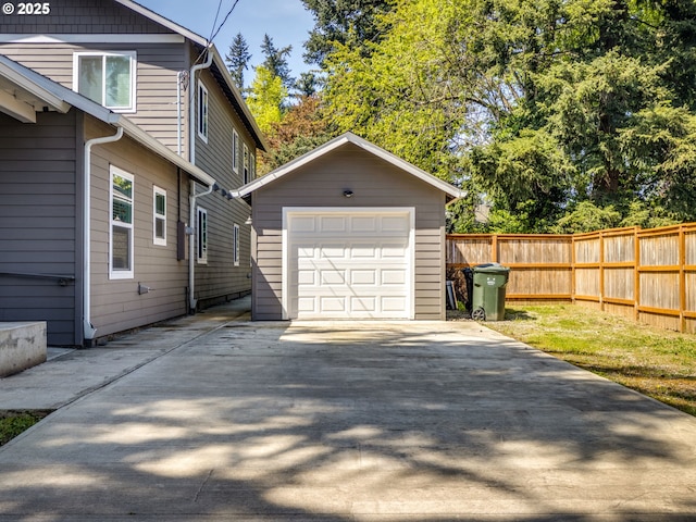 15807 SE Rainier Ave, Clackamas, OR 97015 - view of home's exterior featuring an outdoor structure, concrete driveway, fence, and a detached garage
