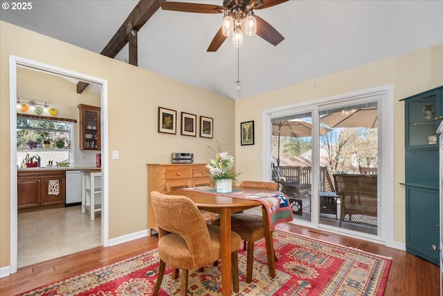 dining room with lofted ceiling, plenty of natural light, light wood-style flooring, and baseboards