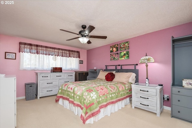 bedroom featuring baseboards, ceiling fan, a textured ceiling, and light colored carpet