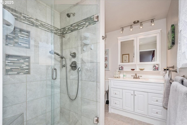 full bath featuring a stall shower, vanity, and tile patterned floors