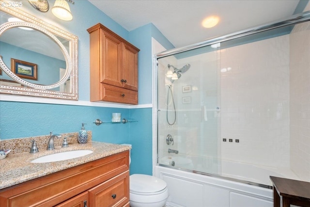 full bath featuring a textured wall, shower / bath combination with glass door, vanity, and toilet