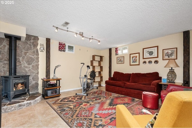 tiled living room featuring a wood stove, baseboards, and a textured ceiling