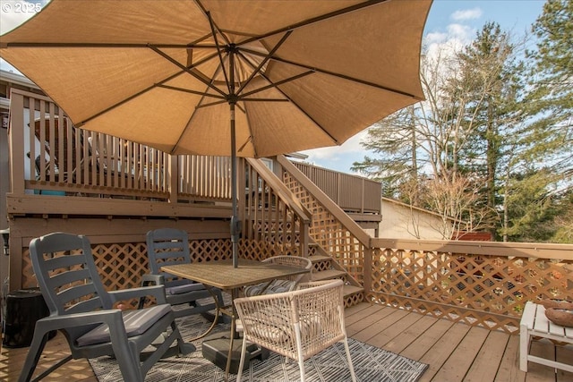 wooden deck featuring stairs and outdoor dining area