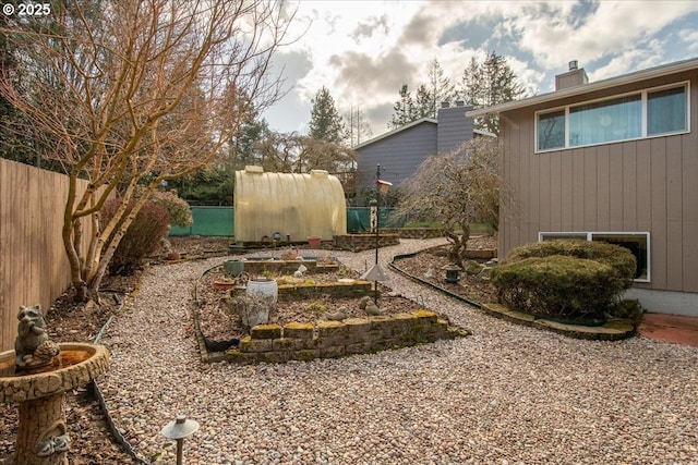 view of yard with fence and an outdoor structure