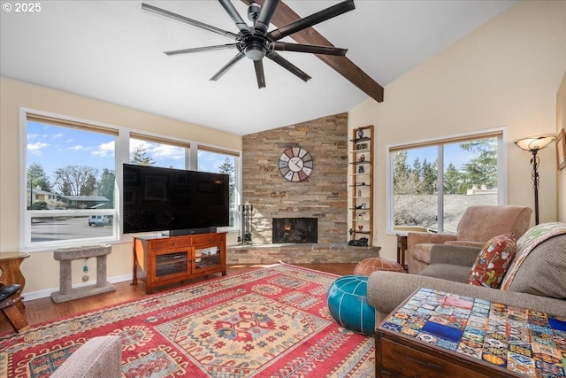 living room featuring beamed ceiling, a fireplace, wood finished floors, and a healthy amount of sunlight