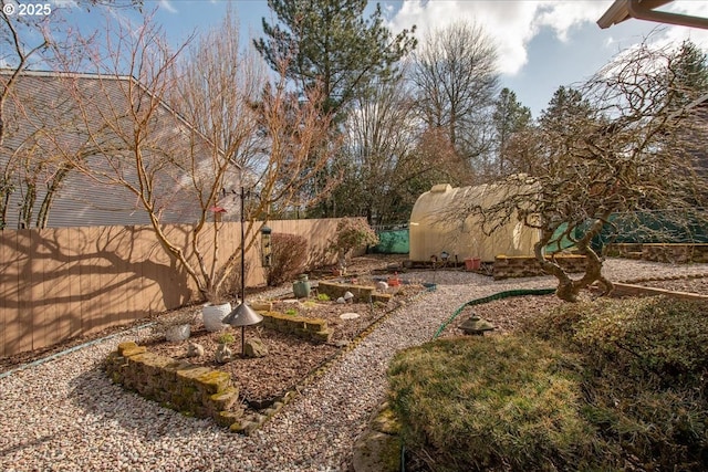 view of yard with an outbuilding and a fenced backyard