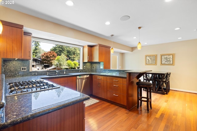 17810 Sarah Hill Ln, Lake Oswego, OR 97035 - kitchen with appliances with stainless steel finishes, a peninsula, brown cabinetry, recessed lighting, and light wood-style floors