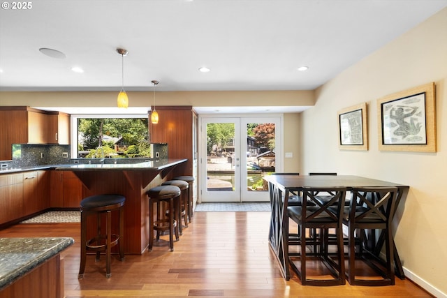 17810 Sarah Hill Ln, Lake Oswego, OR 97035 - kitchen featuring light wood finished floors, brown cabinetry, plenty of natural light, and recessed lighting