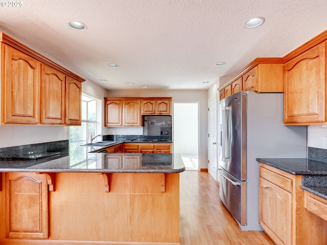 13811 SE 36th St, Vancouver, WA 98683 - kitchen featuring a sink, light wood-type flooring, dark stone counters, a peninsula, and recessed lighting