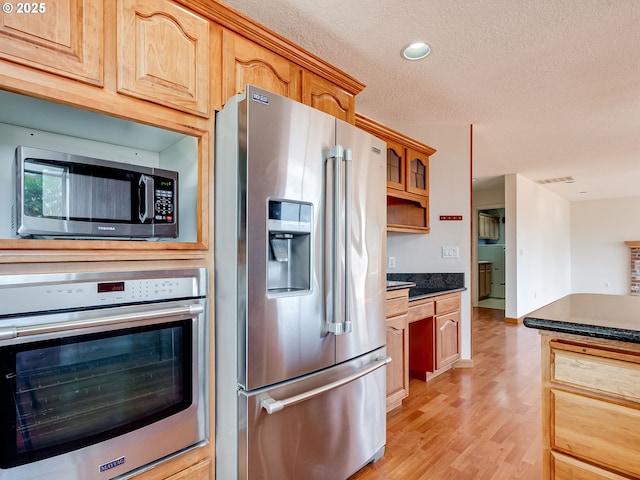 13811 SE 36th St, Vancouver, WA 98683 - kitchen featuring appliances with stainless steel finishes, dark countertops, a textured ceiling, light wood-style flooring, and recessed lighting