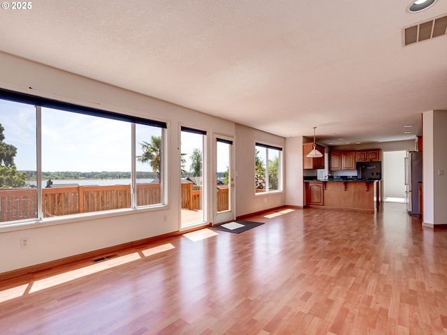 13811 SE 36th St, Vancouver, WA 98683 - unfurnished living room with baseboards, light wood-type flooring, and a water view