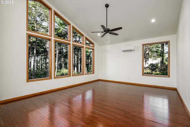 spare room featuring baseboards, ceiling fan, hardwood / wood-style floors, an AC wall unit, and recessed lighting