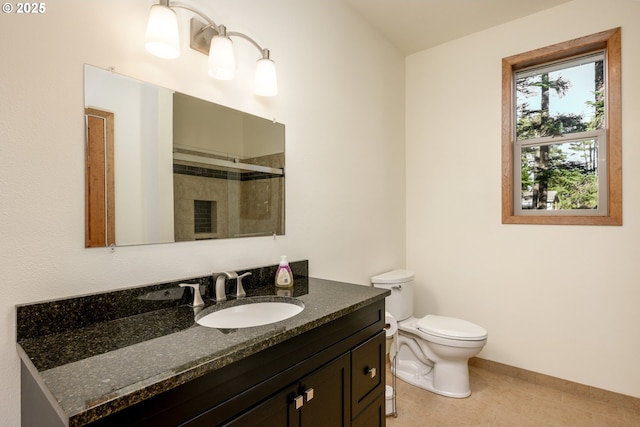 bathroom with vanity, tile patterned flooring, a tile shower, and toilet