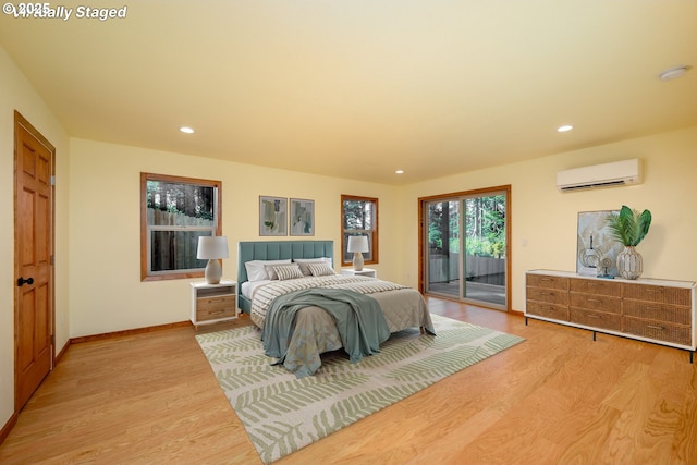 bedroom featuring an AC wall unit, light wood finished floors, recessed lighting, and access to exterior