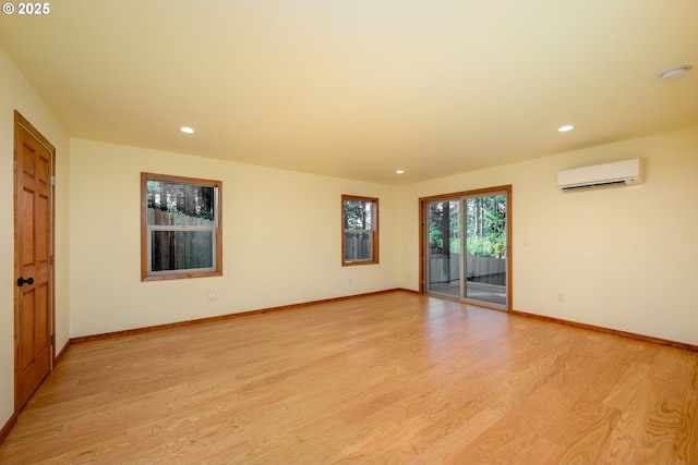 spare room with recessed lighting, light wood-style flooring, baseboards, and a wall mounted AC