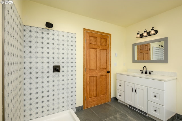 bathroom featuring a tile shower and vanity