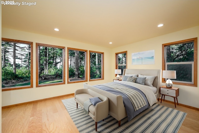 bedroom with recessed lighting, light wood-type flooring, and baseboards