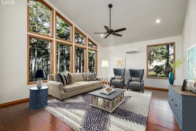 living area featuring high vaulted ceiling, a wall mounted AC, wood-type flooring, and baseboards