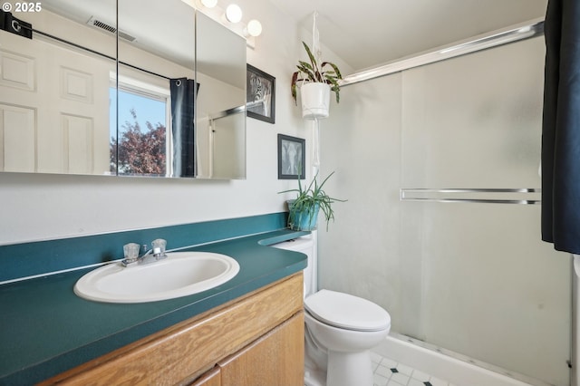 full bathroom with vanity, a shower stall, toilet, and visible vents