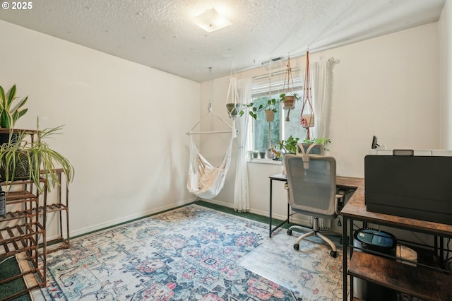 office with carpet flooring, a textured ceiling, and baseboards