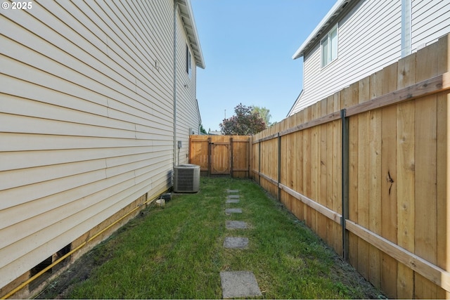 view of yard with a fenced backyard and central AC unit