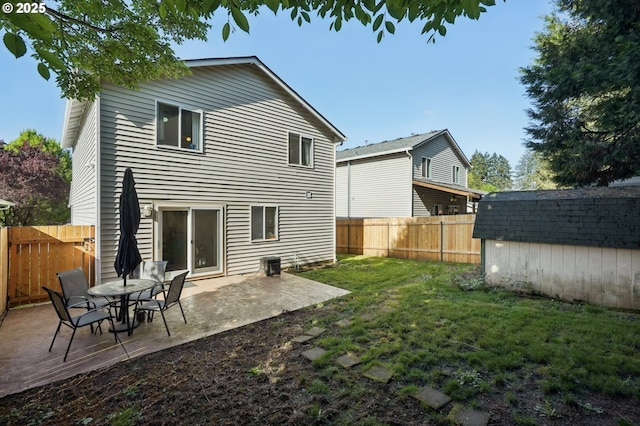 back of house featuring an outdoor structure, a patio, a fenced backyard, a storage shed, and a yard