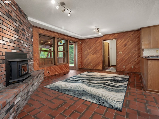 18036 NW Emmaus Ln, Portland, OR 97231 - tiled living room featuring rail lighting, wooden walls, and a wood stove