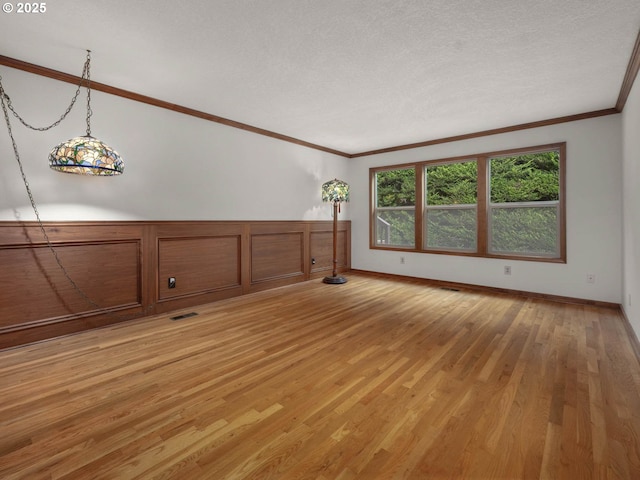 18036 NW Emmaus Ln, Portland, OR 97231 - spare room with light wood-style flooring, ornamental molding, a textured ceiling, and baseboards
