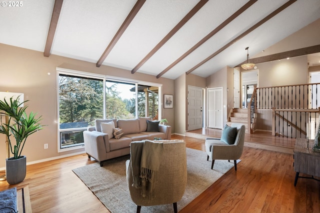 living room with beamed ceiling, high vaulted ceiling, and light hardwood / wood-style floors