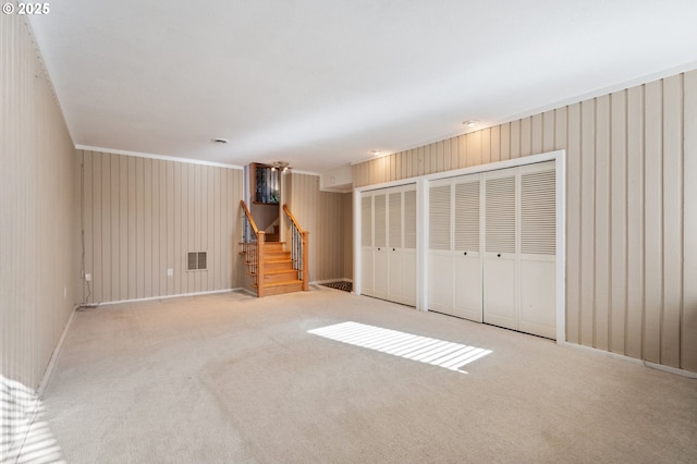 unfurnished bedroom with light carpet and two closets