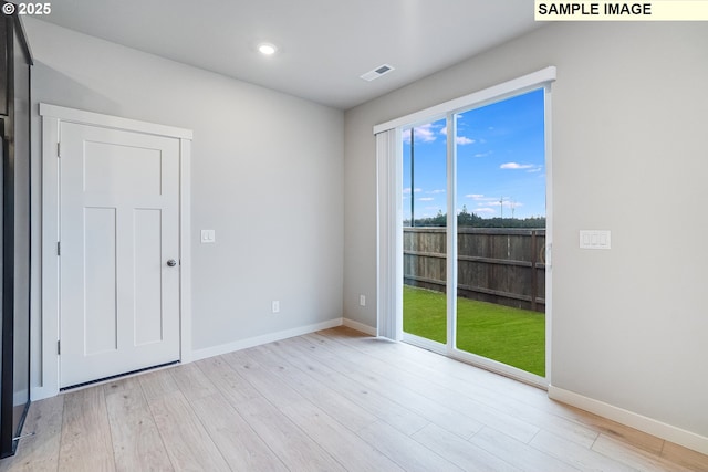 unfurnished room featuring visible vents, baseboards, and wood finished floors