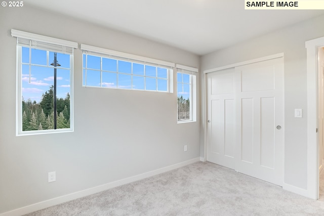 unfurnished bedroom with a closet, baseboards, and carpet