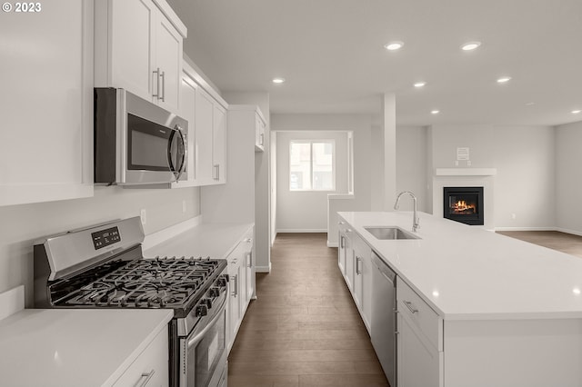 kitchen featuring a sink, stainless steel appliances, white cabinets, and dark wood finished floors