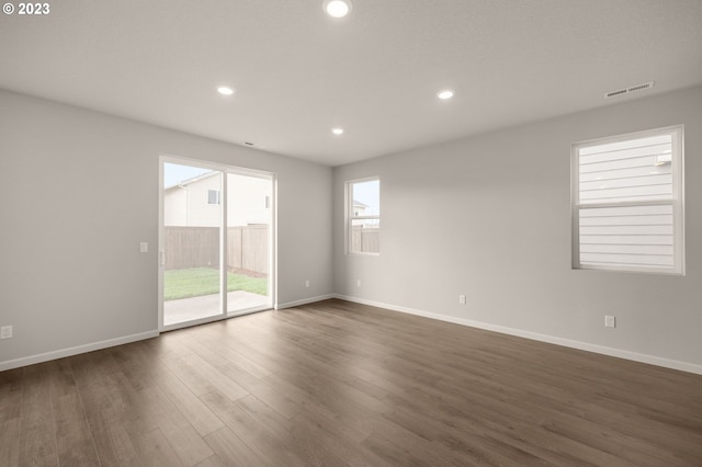 unfurnished room with visible vents, recessed lighting, dark wood-style floors, and baseboards