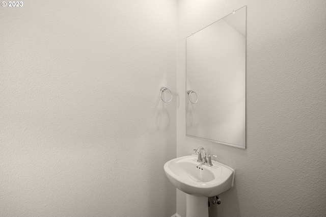 bathroom featuring a textured wall and a sink