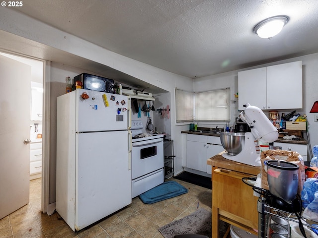 kitchen with a textured ceiling, white appliances, a sink, and white cabinets