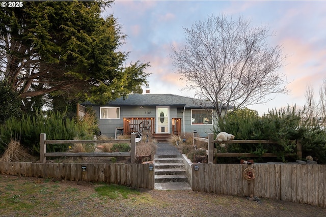 view of front of home with a fenced front yard and a chimney