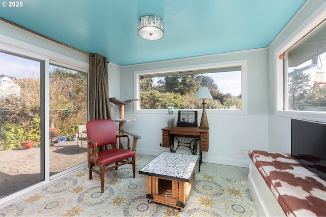 sitting room with tile patterned flooring and wainscoting