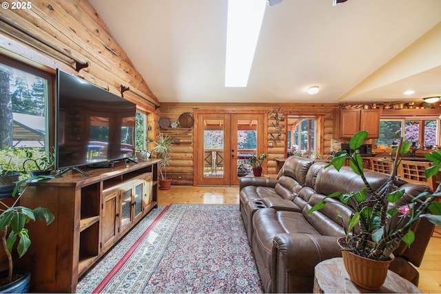 living room featuring light wood-style floors, rustic walls, french doors, and lofted ceiling