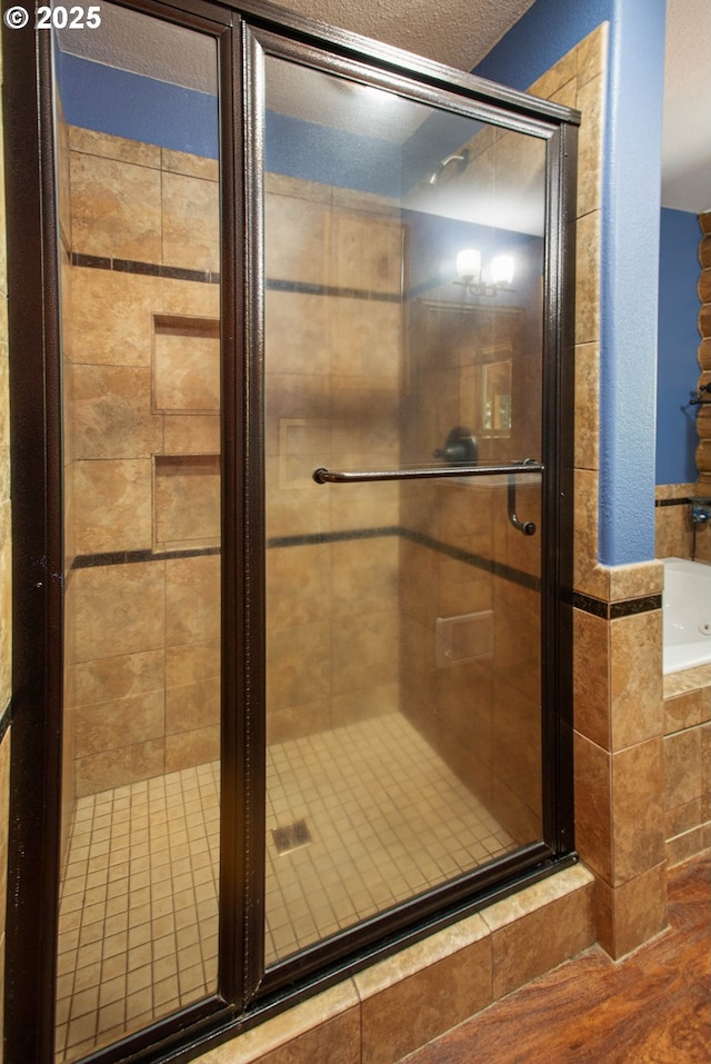 bathroom featuring a shower stall and a bath