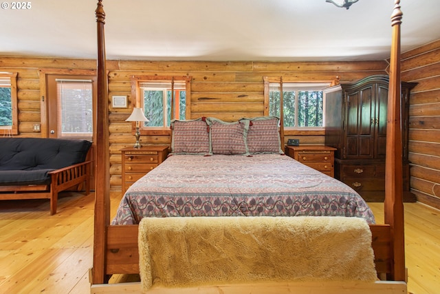 bedroom featuring rustic walls and light wood-type flooring