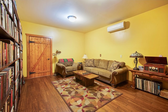 living room featuring wood finished floors and a wall unit AC