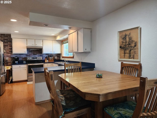 dining room with light wood-style flooring and recessed lighting